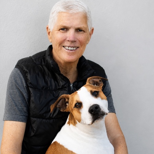 Portrait of Cecilia Fraser with a rescued dog, chair of the board at AfriPaw.