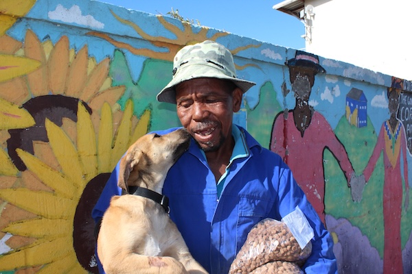 Community member holding his dog supported by AfriPaw.